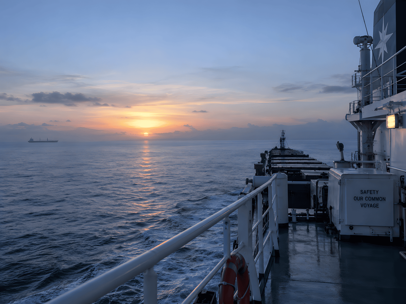 Merchant ship on open ocean at golden hour